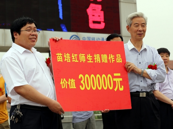 苗培红（右）为确山靖宇小学捐赠价值30万元的书法作品 子玉摄